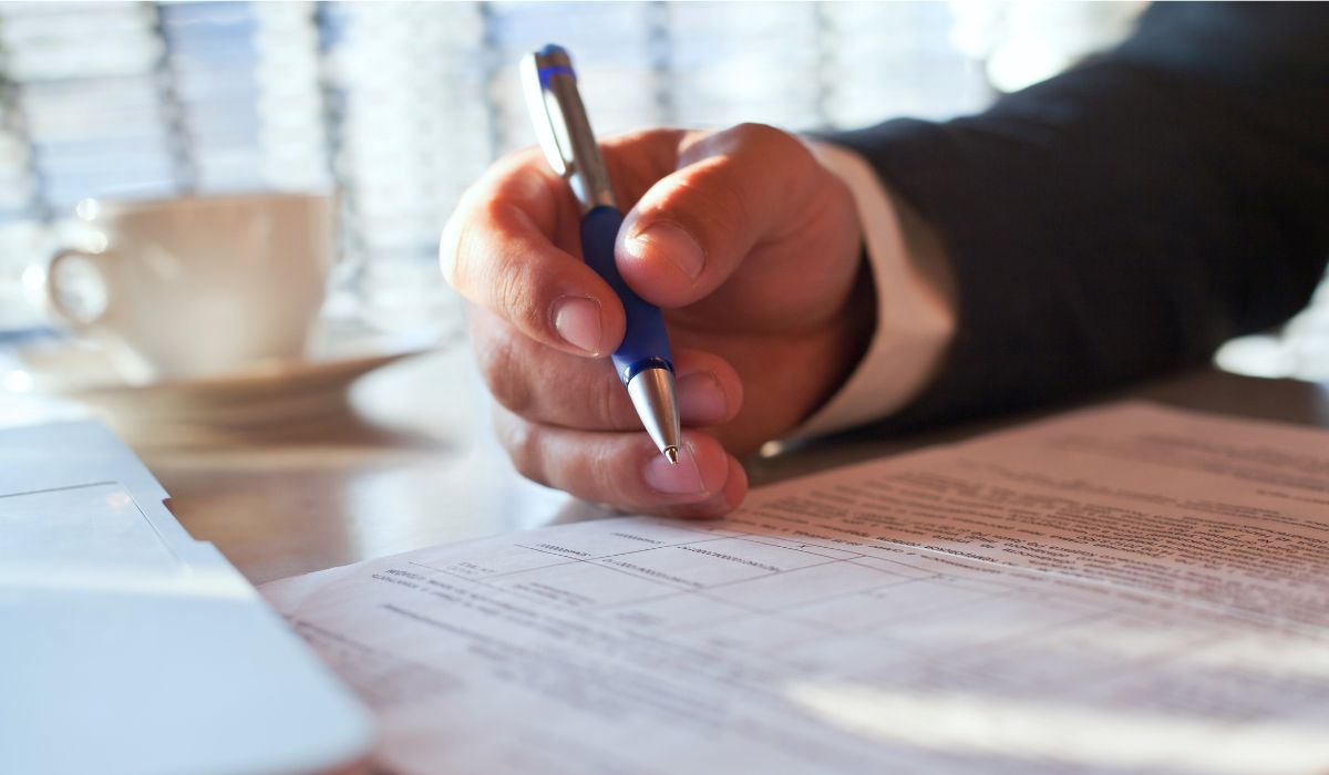 Person reviewing and signing legal paperwork before a consultation with a Brooklyn attorney